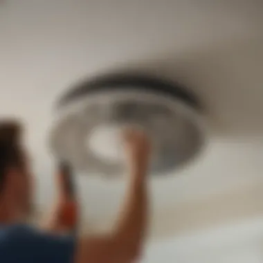 A person using a screwdriver to remove the fan cover