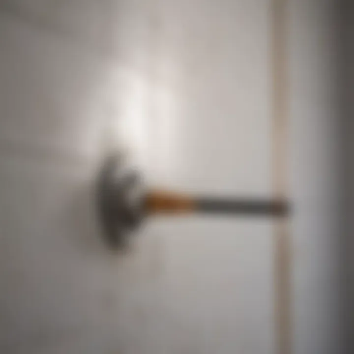 Close-up of a scrubbing tool removing grime from bathroom tile walls